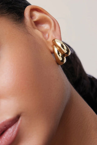 Jenny Bird Orla Earrings in 14K gold-dipped brass, featuring a modern triple-strand sculptural hoop design. these lightweight, high-polish gold earrings add a bold yet sophisticated finish to any professional or evening outfit.