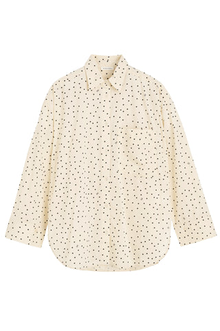 By Malene Birger Derris Shirt in Black and White Polkadot Print crafted from lightweight organic cotton voile. This oversized button down features a classic collar and front patch pocket for a timeless, airy silhouette. 
