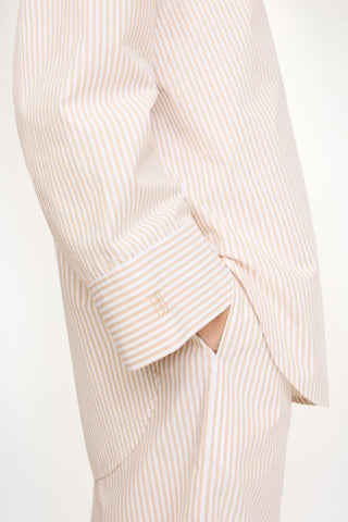 By Malene Birger Derris Shirt in Dark Sand Stripe, featuring a neutral brown and beige vertical pattern in 100% organic cotton. This oversized button-down includes a classic shirt collar and front patch pocket for an effortless Scandinavian look.
