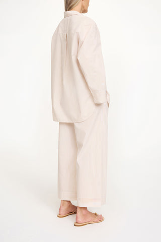 By Malene Birger Derris Shirt in Dark Sand Stripe, featuring a neutral brown and beige vertical pattern in 100% organic cotton. This oversized button-down includes a classic shirt collar and front patch pocket for an effortless Scandinavian look.