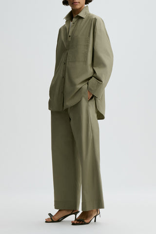 By Malene Birger Mirabello Pants in Deep Lichen Green, crafted from 100% organic cotton with a wide-leg silhouette. These lightweight trousers feature a comfortable high elastic waistband and side pockets for an effortless, relaxed fit.