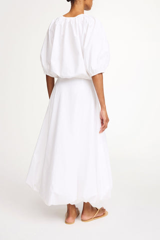 By Malene Birger Lelow Blouse in Pure White, featuring a voluminous silhouette in crisp 100% organic cotton. This versatile top includes an elasticated neckline for on or off-the-shoulder styling, finished with puffed sleeves and an elasticated hem.