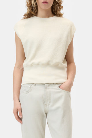 The Closed Sleeveless Crew in Beige is a premium knit top featuring a structured sleeveless design and a wide ribbed hem for a sophisticated, tapered fit. This versatile neutral vest is crafted from high-quality materials, making it an essential layering piece for contemporary minimalist wardrobes.