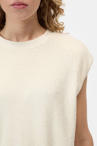 The Closed Sleeveless Crew in Beige is a premium knit top featuring a structured sleeveless design and a wide ribbed hem for a sophisticated, tapered fit. This versatile neutral vest is crafted from high-quality materials, making it an essential layering piece for contemporary minimalist wardrobes.