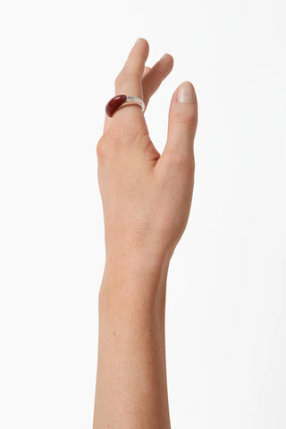 The Beatrice Ring in Sterling Silver with Red Mookiate from Lié Studio features a bold, sculptural dome design crafted from high-quality sterling silver and polished red mookiate stone. This elegant designer statement ring combines modern minimalism with organic textures, making it a sophisticated addition to any contemporary jewelry collection.