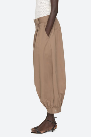 Sea New York Lois Twill Pants in Taupe are mid-waist and feature front pleats and wide belt loops. Balloon leg silhouette with snap button closure at ankles. 