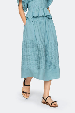Sea New York Violet midi skirt in blue featuring delicate pintuck detailing, an elasticized waistband, and a breezy A-line silhouette. This lightweight cotton skirt offers a relaxed fit, making it a perfect effortless piece for a fresh spring outfit.