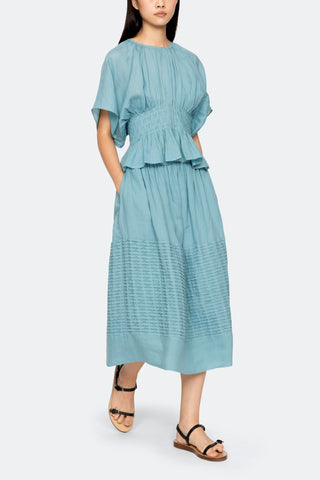 Sea New York Violet Top in light blue cotton featuring short sleeves and intricate pintuck detailing at the waist that creates a subtle peplum hem. This relaxed-fit blouse is a chic, breathable piece perfect for a polished spring or summer look.