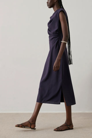 Soeur Eugenie Dress in Violet Fonce, a sophisticated sleeveless midi dress featuring a draped cowl neckline and elegant side-gathering. This premium designer piece in a deep plum purple offers a sleek, feminine silhouette that transitions perfectly from professional gallery openings to formal evening events.