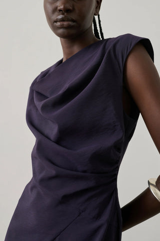 Soeur Eugenie Dress in Violet Fonce, a sophisticated sleeveless midi dress featuring a draped cowl neckline and elegant side-gathering. This premium designer piece in a deep plum purple offers a sleek, feminine silhouette that transitions perfectly from professional gallery openings to formal evening events.
