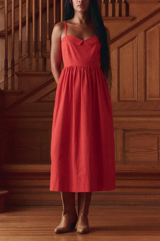 The Great Verse Dress in Hot Red, a sophisticated midi-length sundress featuring a flattering sweetheart neckline and delicate spaghetti straps. This versatile 100% cotton dress offers a timeless, feminine silhouette that transitions seamlessly from elevated daytime events to chic evening gatherings.