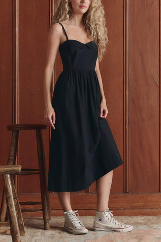 The Great Verse Dress in Black, a sophisticated midi-length sundress featuring a flattering sweetheart neckline and delicate spaghetti straps. This versatile 100% cotton dress offers a timeless, feminine silhouette that transitions seamlessly from elevated daytime events to chic evening gatherings.