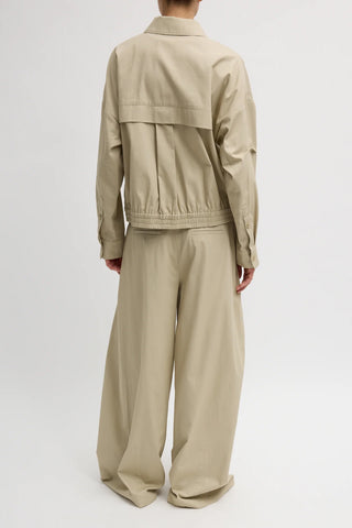 Tibi Luxe Twill Bomber in Taupe, a premium oversized flight jacket featuring a crisp technical twill fabric and signature rib-knit detailing. This luxury transitional layer offers a sophisticated, modern take on utilitarian style that pairs perfectly with tailored trousers or casual denim.