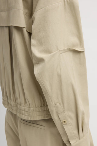Tibi Luxe Twill Bomber in Taupe, a premium oversized flight jacket featuring a crisp technical twill fabric and signature rib-knit detailing. This luxury transitional layer offers a sophisticated, modern take on utilitarian style that pairs perfectly with tailored trousers or casual denim.