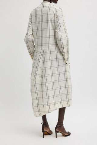 Tibi Russel Plaid Balloon Dress in Ivory/Black, a sophisticated midi-length dress featuring a modern oversized check pattern and a unique sculptural balloon silhouette. This designer piece offers a refined, architectural look with a concealed front placket and long sleeves, perfect for making a stylish statement at professional or social events.