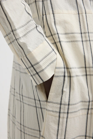 Tibi Russel Plaid Balloon Dress in Ivory/Black, a sophisticated midi-length dress featuring a modern oversized check pattern and a unique sculptural balloon silhouette. This designer piece offers a refined, architectural look with a concealed front placket and long sleeves, perfect for making a stylish statement at professional or social events.